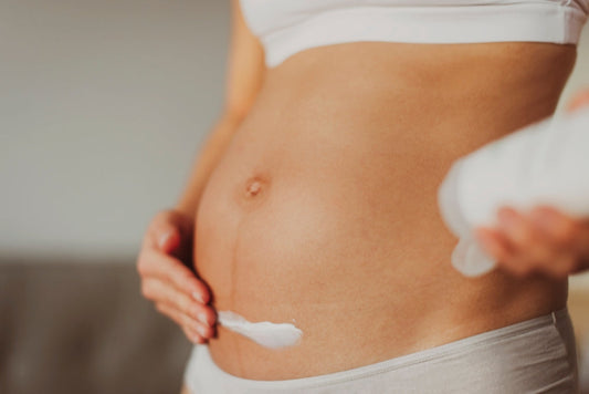 Pregnant women applying emollient to her belly, soothing the eczema itch